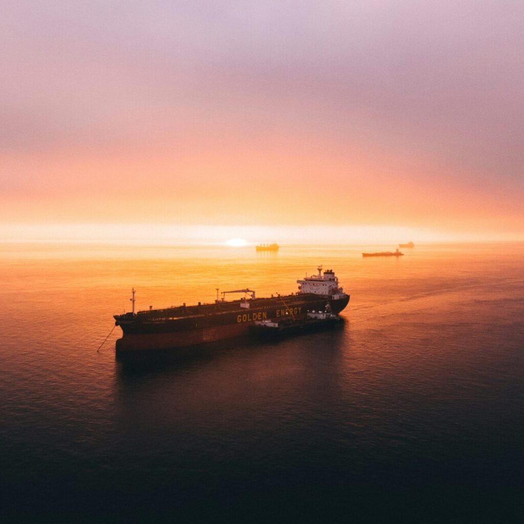 A loaded cargo ship sailing into the sunset