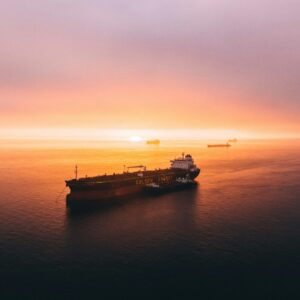 A loaded cargo ship sailing into the sunset