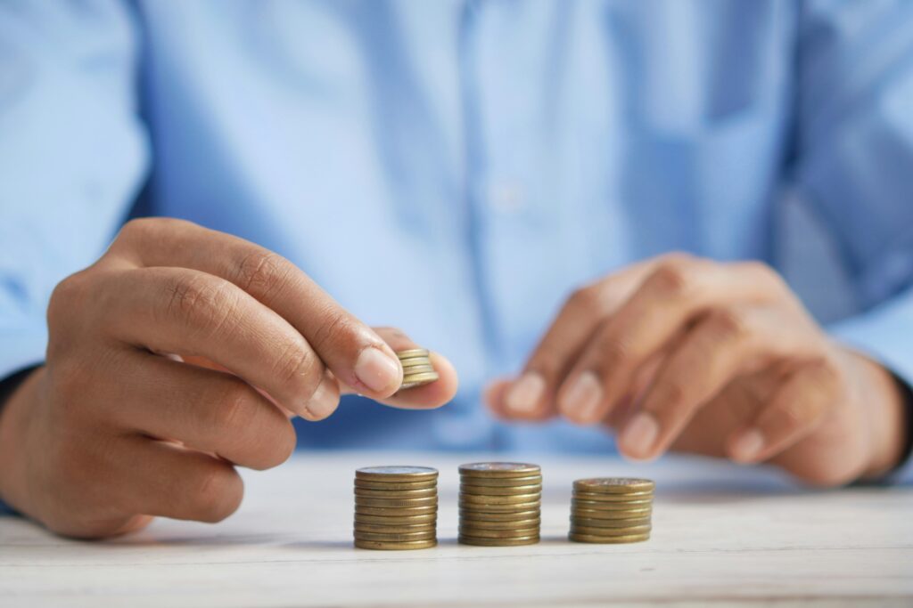 A blue shirted office worker counting stacks of pennies